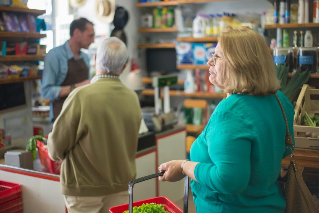 bon senioralny – seniorkę robiące zakupy w supermarkecie